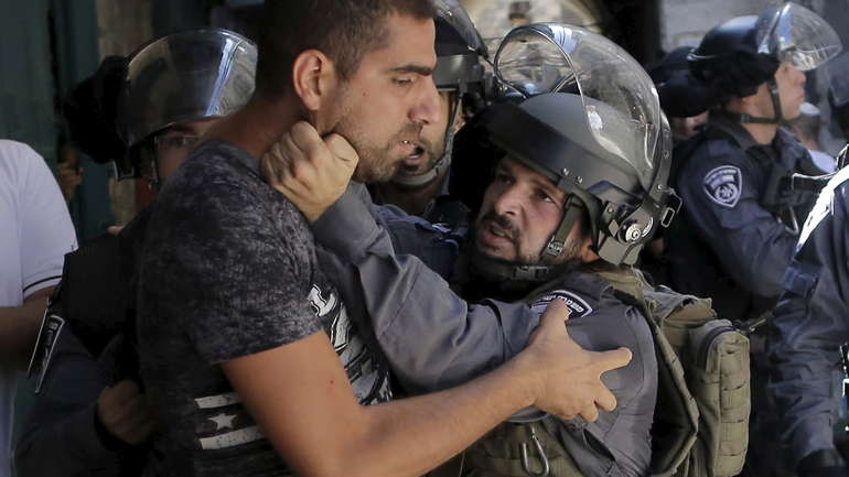 Židovski policajac sprječava palestinskog muslimana da uđe u kompleks Mesdžidul-Aksa