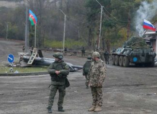 Šta dogovor o Nagorno-Karabahu znači za Rusiju i Tursku? An Azerbaijani service member and a Russian peacekeeper stand guard at a checkpoint on the outskirts of Shusha