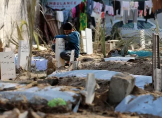 Brojne porodice su potpuno nestale tokom razaranja Gaze Palestinski dječak posjećuje grob člana porodice ubijenog i pokopanog u krugu bolnice al-Shifa u gradu Gazi (AP)