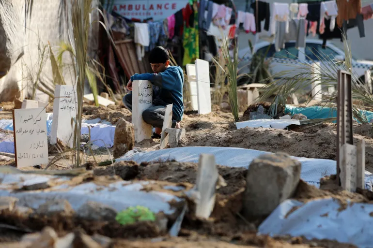 Palestinski dječak posjećuje grob člana porodice ubijenog i pokopanog u krugu bolnice al-Shifa u gradu Gazi (AP)